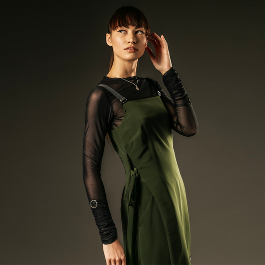 green pinafore dress with black long sleeve mesh top out of sync